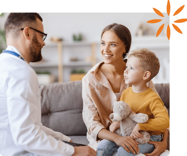 Healthcare provider talking with a parent and child during a pediatric visit.
