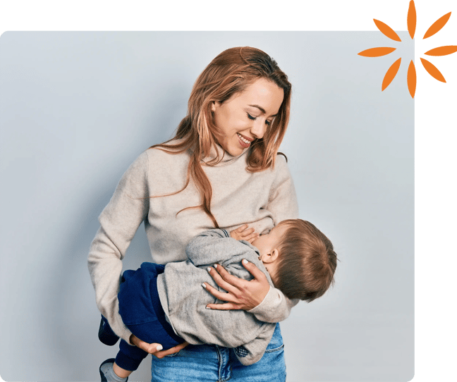 Mother breastfeeding her baby while sitting comfortably at home in a calm, nurturing environment.