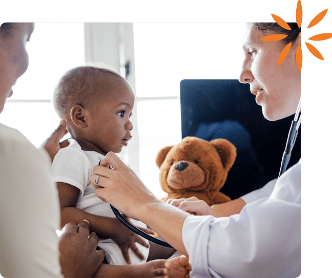 Healthcare provider examining a baby while a parent looks on during a checkup.