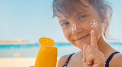 child using sunscreen to protect from pediatric skin cancer
